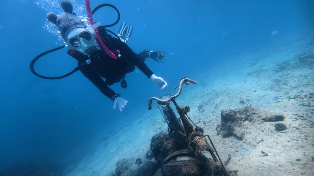 A diver holding a stable, motionless hover above the reef